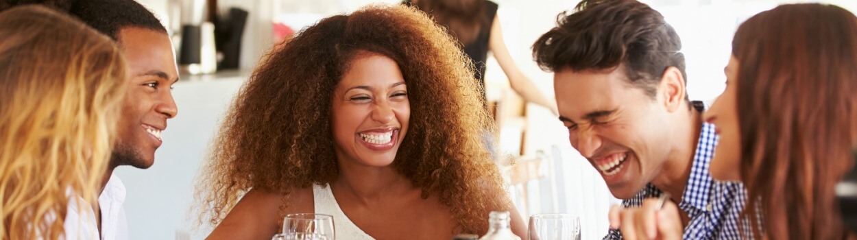 A group of people laughing and having conversation.